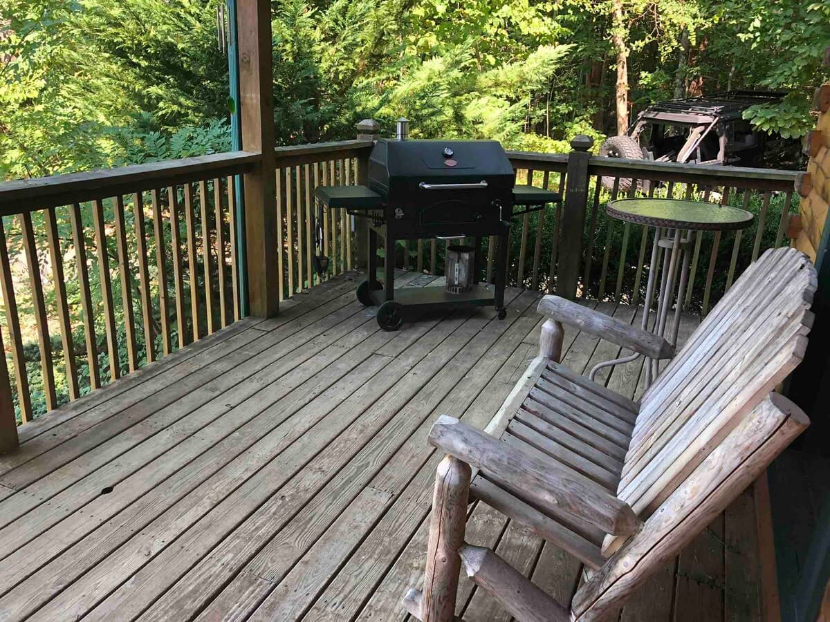 Bathroom with pine walls, white vanity, iron towel rack with fresh towels, and red valance window