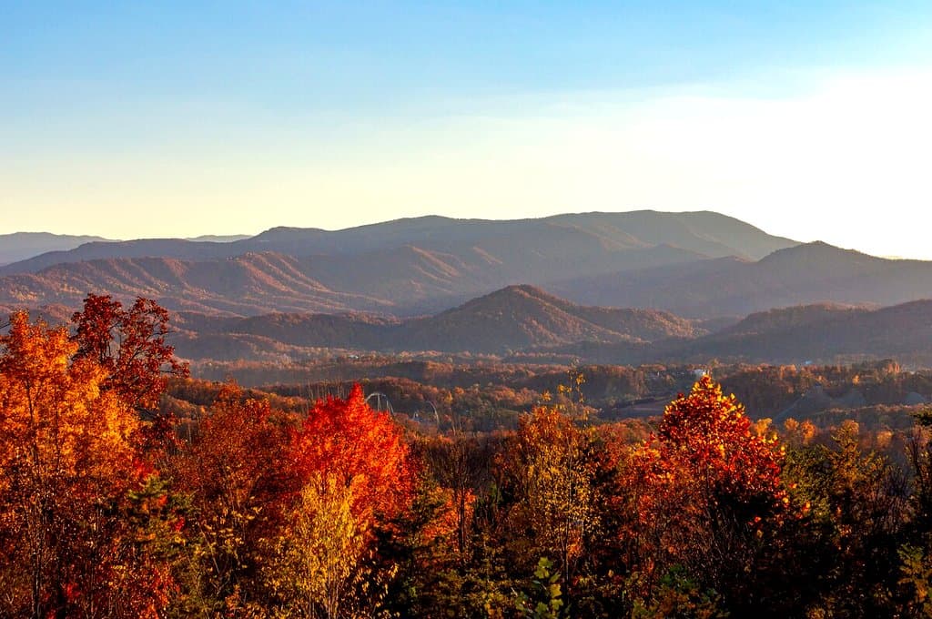 Mountain ridges rising beyond bright autumn foliage
