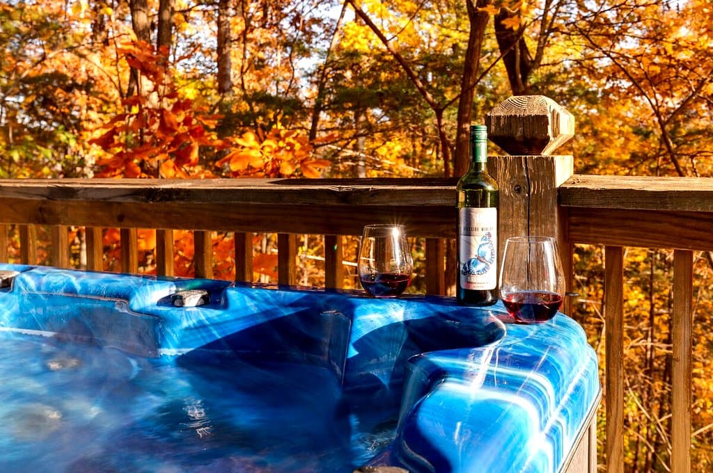Hot tub beside the deck railing with autumn trees beyond