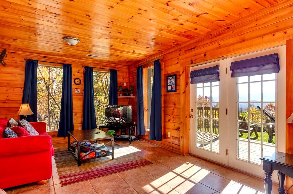 Lower-level lounge with red sofas, television and deck doors